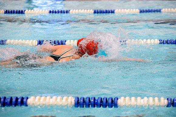 Students of varying swim teams compete in different swimming events.