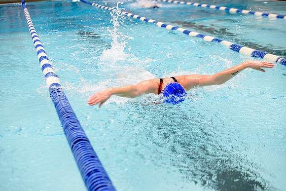 Students of varying swim teams compete in different swimming events.