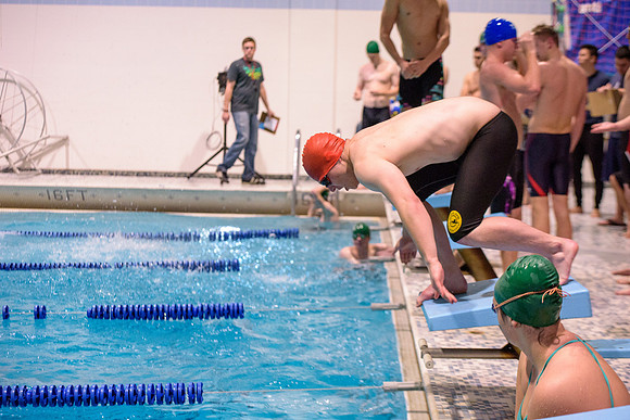 Students of varying swim teams compete in different swimming events.
