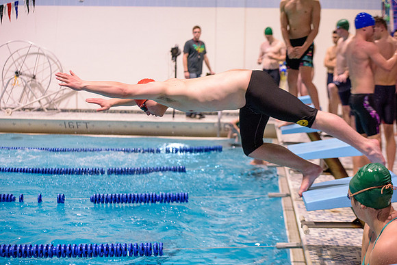 Students of varying swim teams compete in different swimming events.