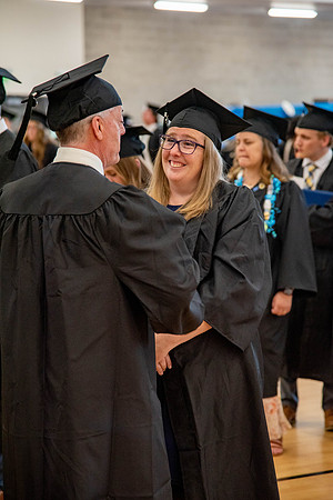 Students before commencement, talking with family and friends.
