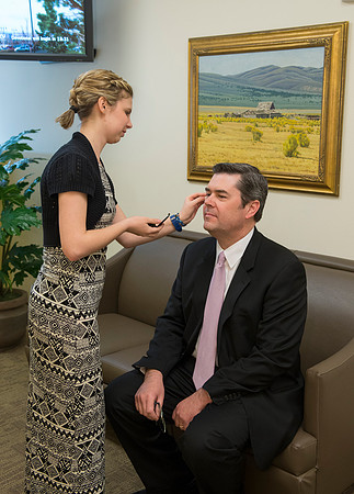 Behind the scenes of devotional, the speaker, Drew Eader, gets a little powder to reduce the shine from the bright lights.