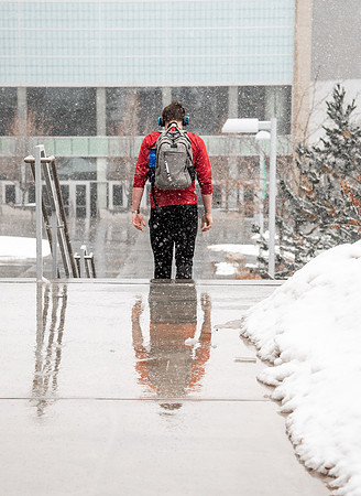 BYUI students walk around campus as it snows and rains.