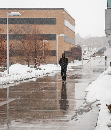 BYUI students walk around campus as it snows and rains.