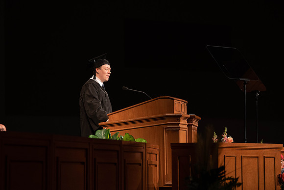 Students partipate in walking to graduate from the College of Business and Communication.
