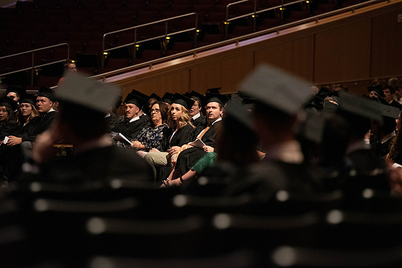 Students partipate in walking to graduate from the College of Business and Communication.