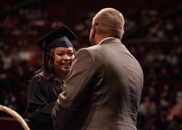 Students partipate in walking to graduate from the College of Business and Communication.