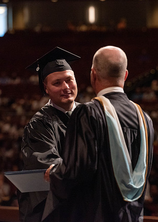 Students partipate in walking to graduate from the College of Business and Communication.
