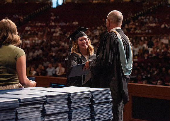 Students partipate in walking to graduate from the College of Business and Communication.