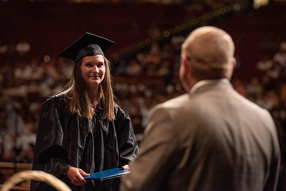 Students partipate in walking to graduate from the College of Business and Communication.