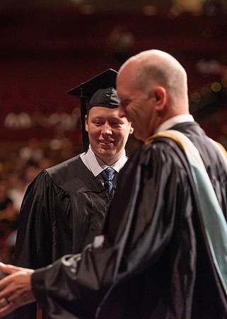 Students partipate in walking to graduate from the College of Business and Communication.