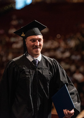 Students partipate in walking to graduate from the College of Business and Communication.
