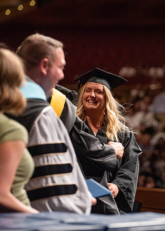 Students partipate in walking to graduate from the College of Business and Communication.