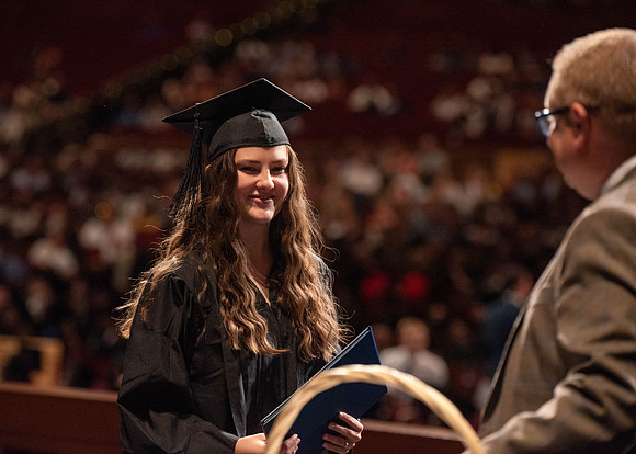 Students partipate in walking to graduate from the College of Business and Communication.