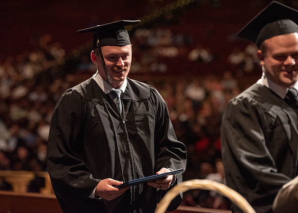 Students partipate in walking to graduate from the College of Business and Communication.