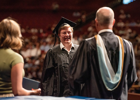 Students partipate in walking to graduate from the College of Business and Communication.