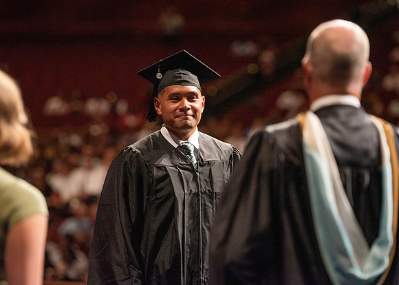 Students partipate in walking to graduate from the College of Business and Communication.