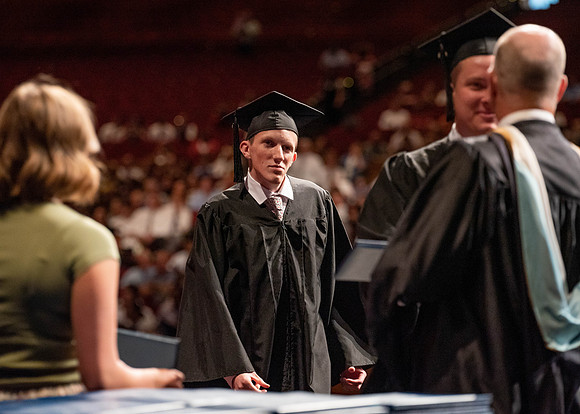 Students partipate in walking to graduate from the College of Business and Communication.