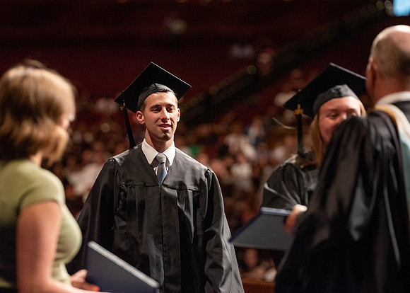 Students partipate in walking to graduate from the College of Business and Communication.
