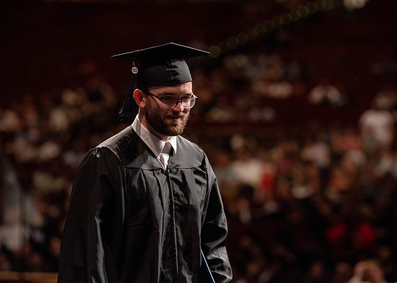 Students partipate in walking to graduate from the College of Business and Communication.