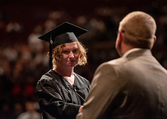 Students partipate in walking to graduate from the College of Business and Communication.