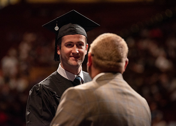 Students partipate in walking to graduate from the College of Business and Communication.
