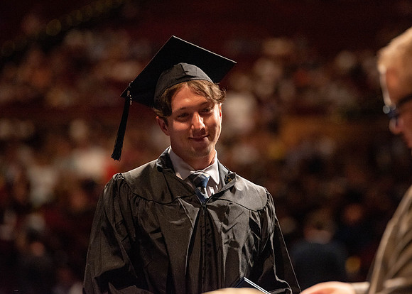 Students partipate in walking to graduate from the College of Business and Communication.