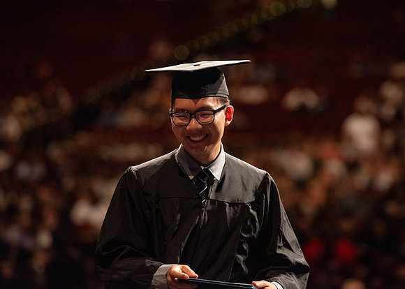 Students partipate in walking to graduate from the College of Business and Communication.