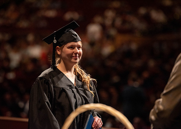 Students partipate in walking to graduate from the College of Business and Communication.