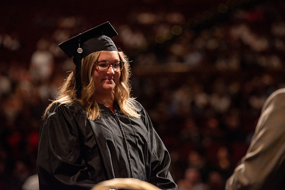 Students partipate in walking to graduate from the College of Business and Communication.