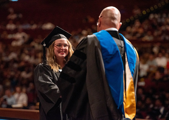 Students partipate in walking to graduate from the College of Business and Communication.