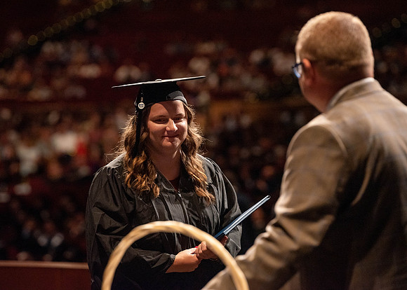 Students partipate in walking to graduate from the College of Business and Communication.