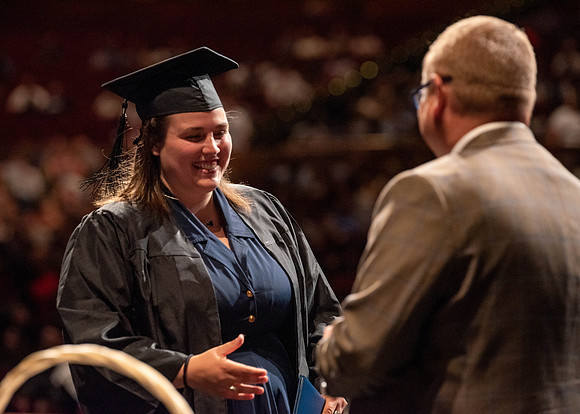 Students partipate in walking to graduate from the College of Business and Communication.