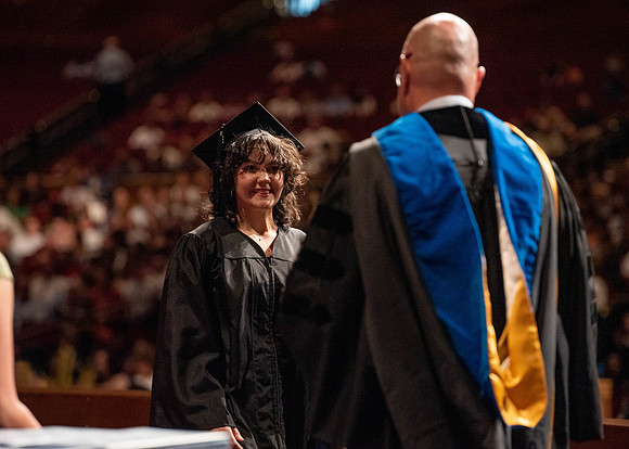 Students partipate in walking to graduate from the College of Business and Communication.