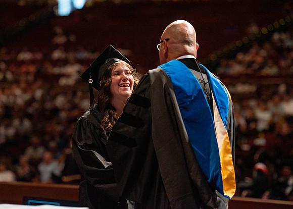 Students partipate in walking to graduate from the College of Business and Communication.