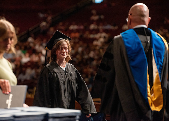Students partipate in walking to graduate from the College of Business and Communication.