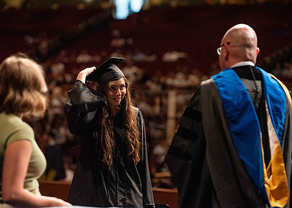 Students partipate in walking to graduate from the College of Business and Communication.