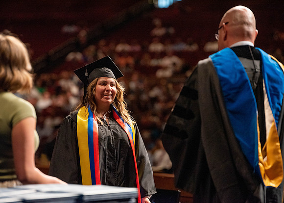 Students partipate in walking to graduate from the College of Business and Communication.