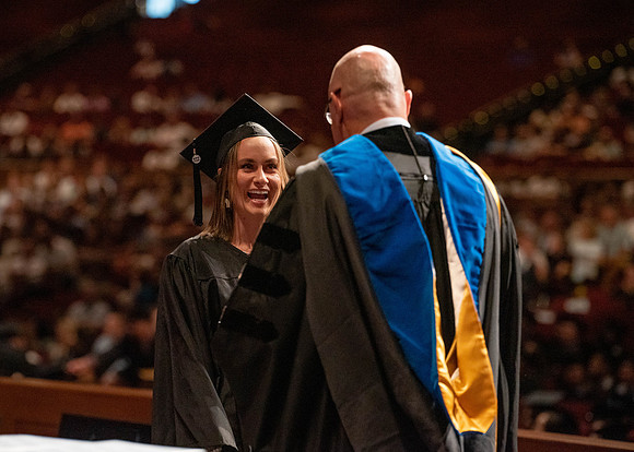 Students partipate in walking to graduate from the College of Business and Communication.
