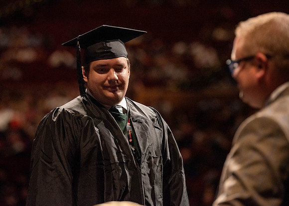 Students partipate in walking to graduate from the College of Business and Communication.