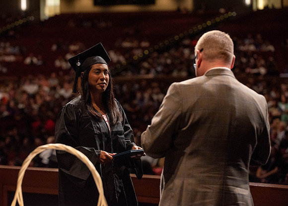 Students partipate in walking to graduate from the College of Business and Communication.
