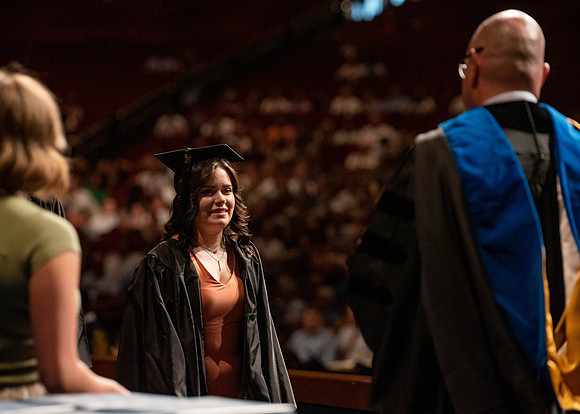 Students partipate in walking to graduate from the College of Business and Communication.
