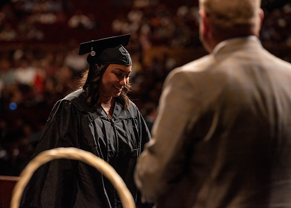 Students partipate in walking to graduate from the College of Business and Communication.