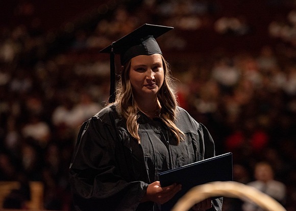 Students partipate in walking to graduate from the College of Business and Communication.