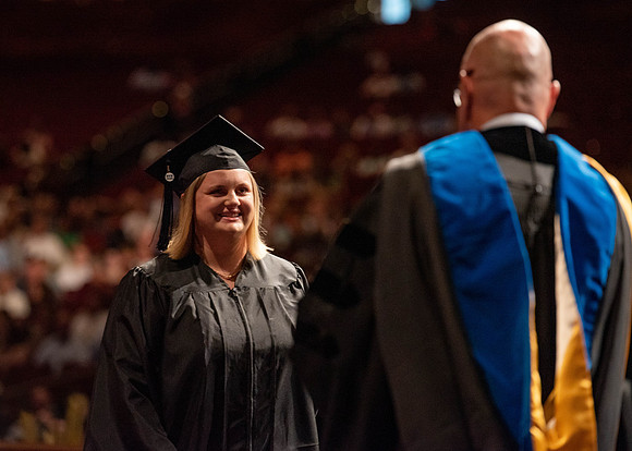 Students partipate in walking to graduate from the College of Business and Communication.