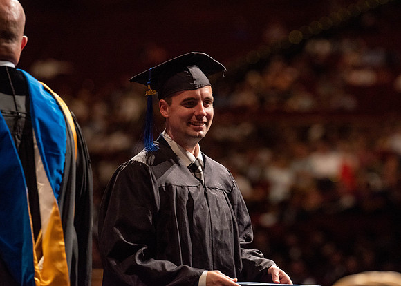 Students partipate in walking to graduate from the College of Business and Communication.