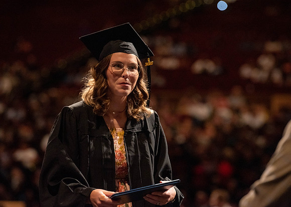 Students partipate in walking to graduate from the College of Business and Communication.
