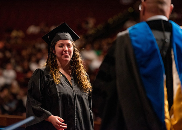 Students partipate in walking to graduate from the College of Business and Communication.