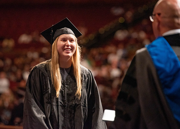 Students partipate in walking to graduate from the College of Business and Communication.