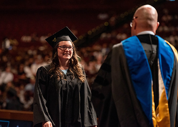 Students partipate in walking to graduate from the College of Business and Communication.